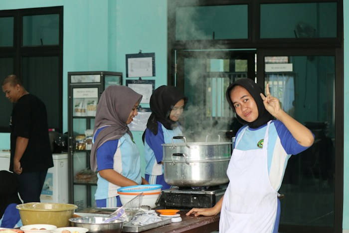 Young Indonesian helper candidates practising cooking skills in a training kitchen